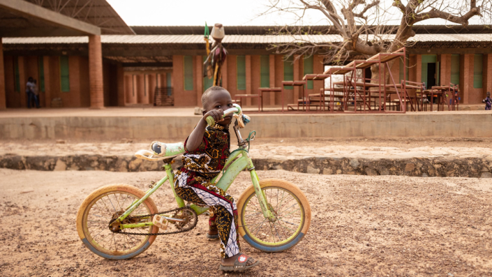 A child on a bicycle at the Village-Opera school in Laongo, Burkina Faso - Wednesday 16 March 2022