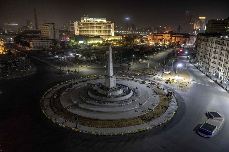 FILE - In this March 29, 2020 file photo, Tahrir Square, which was the focal point of the Jan. 25, 2011 Egyptian uprising that toppled autocrat Hosni Mubarak, is closed off by police during curfew hours as a prevention measures due to the coronavirus outbreak, in Cairo, Egypt. Even as Egyptian authorities fight the swelling coronavirus outbreak, security agencies have tried to stifle criticism about the handling of the health crisis by the government of President Abdel Fattah el-Sissi. (AP Photo/Nariman El-Mofty, File)