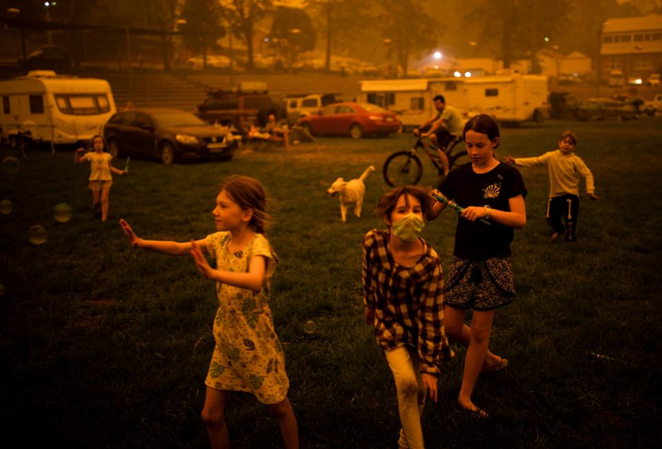 Children play at the showgrounds in the southern New South Wales town of Bega where they are camping after being evacuated from nearby sites affected by bushfires on December 31, 2019. - Thousands of holidaymakers and locals were forced to flee to beaches in fire-ravaged southeast Australia on December 31, as blazes ripped through popular tourist areas leaving no escape by land. (Photo by SEAN DAVEY / AFP) (Photo by SEAN DAVEY/AFP via Getty Images)