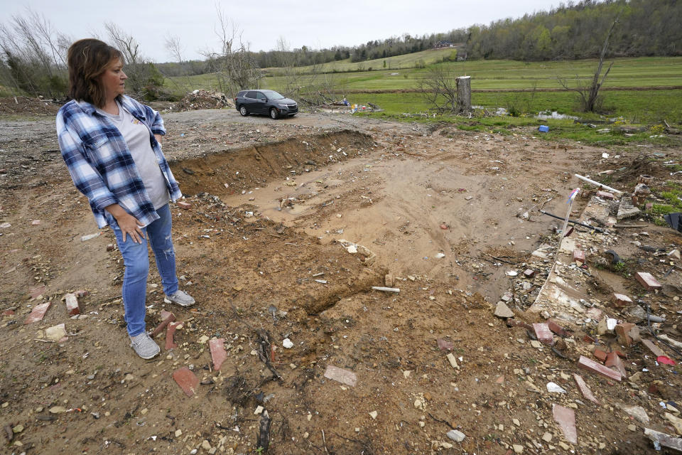 CORRECTS STATE TO KENTUCKY INSTEAD OF TENNESSEE - Chris Bullock looks into the basement area of her former home April 21, 2022, in Dawson Springs, Ky. Bullock, her husband, a son, and family dog survived a massive tornado by huddling in a corner of the basement Dec. 10. Four months after the tornado upended her family's lives, Bullock and hundreds of other Kentuckians are arduously reconstructing their pre-storm existence. (AP Photo/Mark Humphrey)