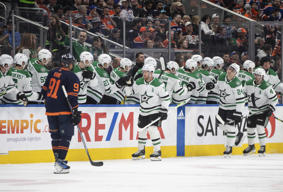 Dallas Stars' Joe Pavelski (16), Roope Hintz (24) and Miro Heiskanen (4) celebrate a goal as Edmonton Oilers' Evander Kane (91) skates past during the second period of an NHL hockey game Thursday, Nov. 2, 2023, in Edmonton, Alberta. (Jason Franson/The Canadian Press via AP)