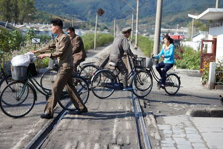 Commuters cross railroad tracks on the outskirts of the North Korean town of Wonsan October, 2016. Christian Peterson-Clausen/Handout via REUTERS