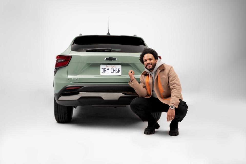 Everette Taylor posing with rear view of Chevrolet Trax ACTIV in Cacti Green. Preproduction model shown. Actual production model may vary. Available Spring 2023. Cacti Green exterior color late availability.