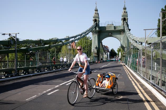 A cyclist rides over Hammersmith Bridge on July 17. The bridge was closed last year after cracks in the bridge worsened during a heatwave (Photo: Hollie Adams via Getty Images)
