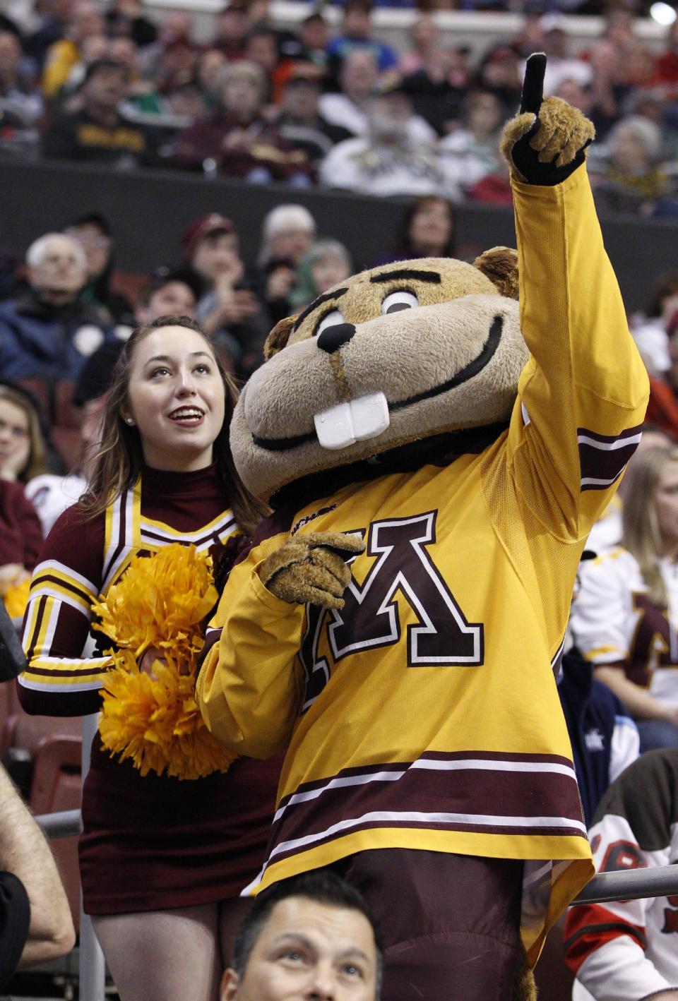 Minnesota's mascot Goldy points things out to one of the cheerleaders during the third period of an NCAA men's college hockey Frozen Four tournament game against North Dakota, Thursday, April 10, 2014, in Philadelphia. Minnesota won 2-1. (AP Photo/Chris Szagola)