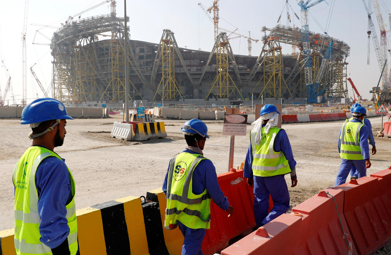 Workers walk towards the construction site of the Lusail stadium which will be build for the upcoming 2022 Fifa soccer World Cup during a stadium tour in Doha, Qatar, December 20, 2019.  REUTERS/Kai Pfaffenbach