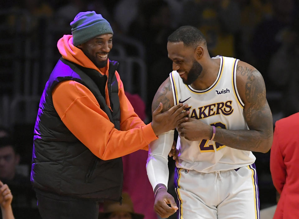 LOS ANGELES, CA - DECEMBER 29: LeBron James #23 of the Los Angeles Lakers has a moment on the sideline with former Laker Kobe Bryant in the second half during a game against the Dallas Mavericks at Staples Center on December 29, 2019 in Los Angeles, California. NOTE TO USER: User expressly acknowledges and agrees that, by downloading and/or using this photograph, user is consenting to the terms and conditions of the Getty Images License Agreement. (Photo by John McCoy/Getty Images)