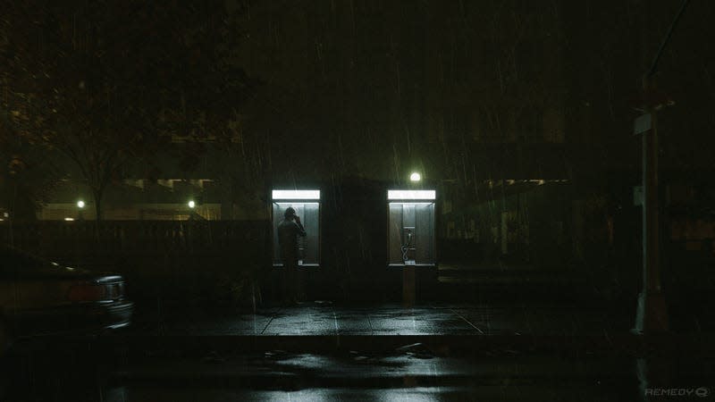 A man uses a payphone on a dark, wet street.