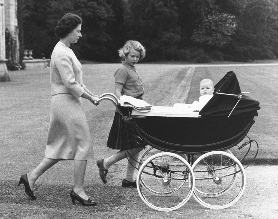 FILE - Britain's Queen Elizabeth II strolls in the grounds of her Scottish home in Balmoral castle, Scotland, with Princess Anne and Prince Andrew, Sept. 13, 1960. When the hearse carrying Queen Elizabeth II's body pulled out of the gates of Balmoral Castle on Sunday, Sept. 11, 2022, it marked the monarch's final departure from a personal sanctuary where she could shed the straitjacket of protocol and ceremony for a few weeks every year. The sprawling estate in the Scottish Highlands west of Aberdeen was a place where Elizabeth rode her beloved horses, picnicked, and pushed her children around the grounds on tricycles and wagons, setting aside the formality of Buckingham Palace. (AP Photo, File)