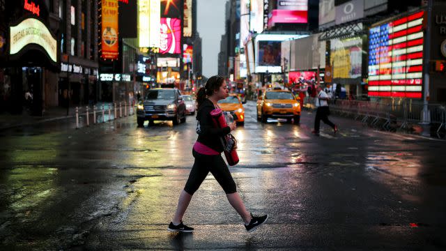 A woman arrives to practice yoga in Times Square as part of a Summer Solstice and International Day of Yoga celebration in New York June 21, 2015.