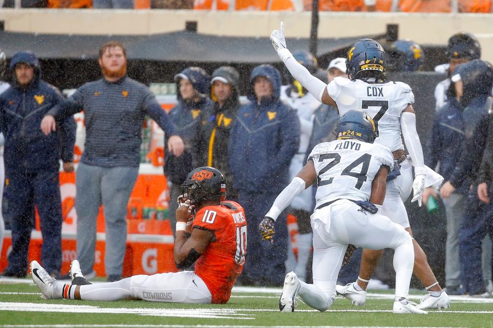 West Virginia linebacker Jasir Cox (7) and safety Marcis Floyd (24) celebrate after breaking up a pass intended for Oklahoma State receiver Rashod Owens (10) during the Mountaineers' 24-19 win Saturday in Stillwater.