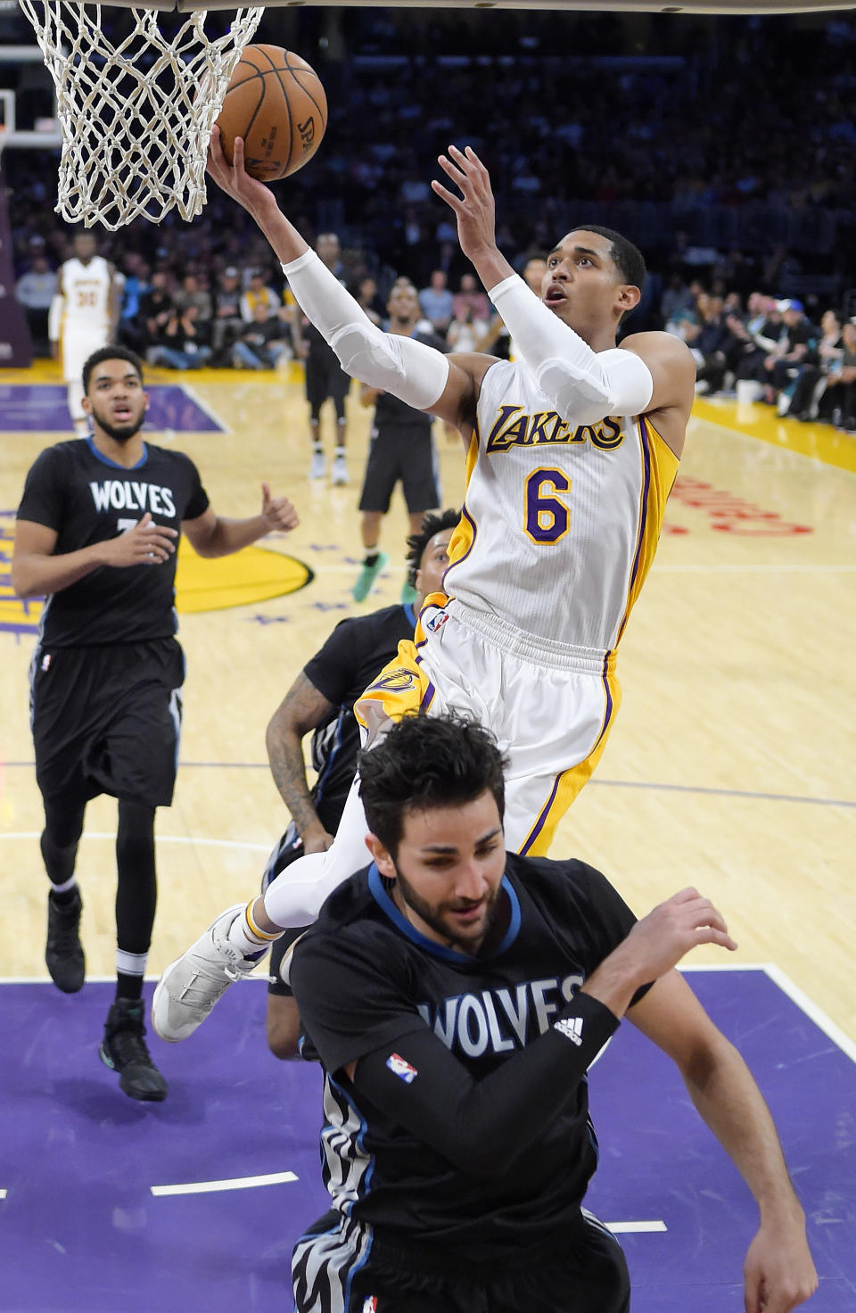 Los Angeles Lakers guard Jordan Clarkson, right, shoots as Minnesota Timberwolves center Karl-Anthony Towns, left, and guard Ricky Rubio, of Spain, defend during the first half of an NBA basketball game, Sunday, April 9, 2017, in Los Angeles. (AP Photo/Mark J. Terrill)