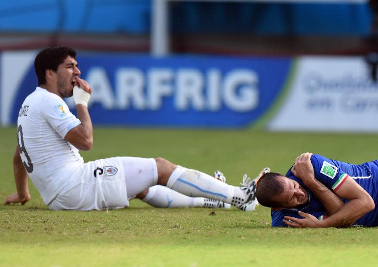 Uruguay's Luis Suarez (L) reacts after appearing to bite Italy's Giorgio Chiellini during their World Cup Group D match, at the Dunas Arena in Natal, Brazil, on June 24, 2014