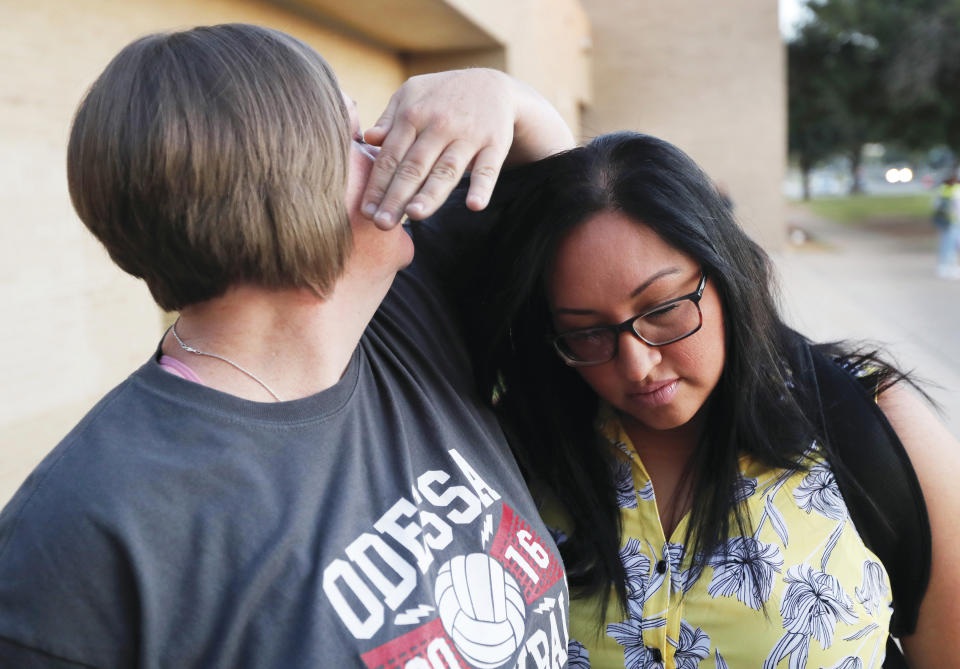 Crockett Middle School teacher Stacy King hugs EAAR Team Teacher Niebes McCalister after a pre-school prayer, Tuesday, Sept. 3, 2019, in front of Crockett Middle School in Odessa, Texas, in remembrance of the mass shooting in Odessa and Midland last Saturday. (Mark Rogers/Odessa American via AP)