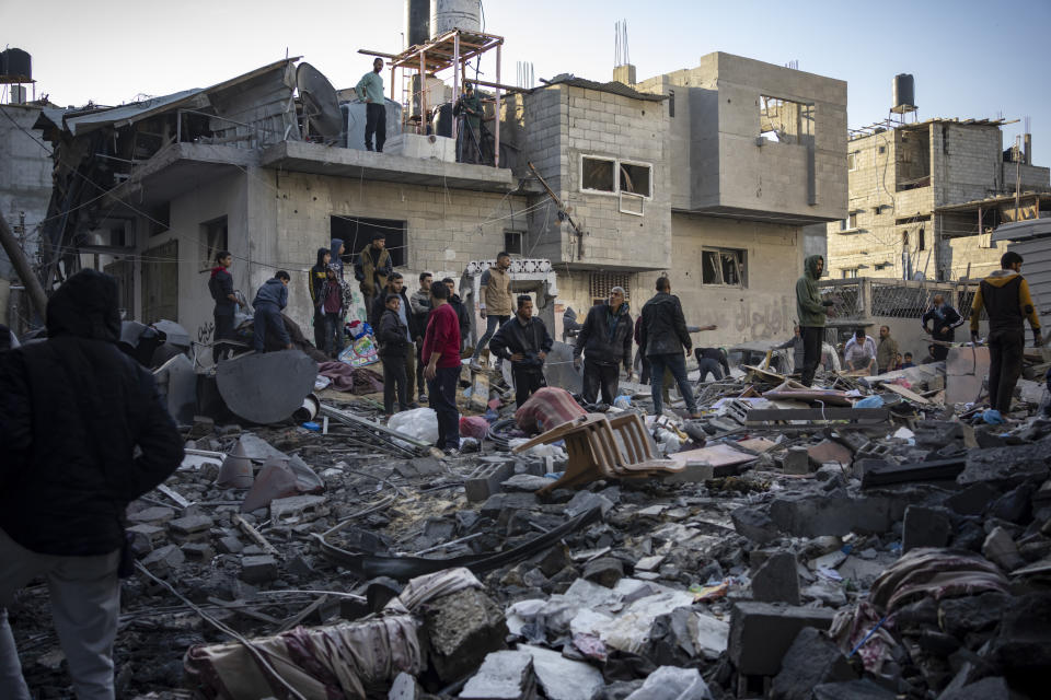 Palestinians look at houses destroyed in the Israeli bombardment of the Gaza Strip in Rafah on Saturday, Dec. 9, 2023. (AP Photo/Fatima Shbair)
