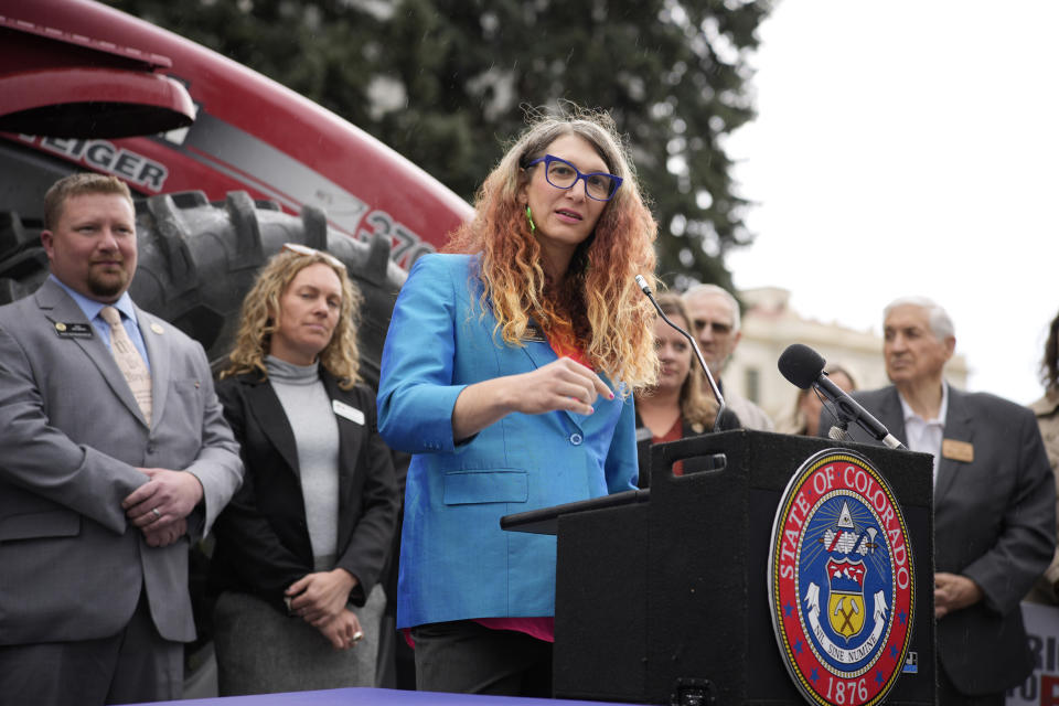 Colorado State Rep. Brianna Titone makes a point before Colorado Gov. Jared Polis signs legislation that forces manufacturers to provide the necessary manuals, tools, parts and even software to farmers so they can fix their own machines Tuesday, April 25, 2023, during a ceremony outside the State Capitol in downtown Denver. Colorado is the first state to put the right-to-repair law into effect while at least 10 other states are considering similar measures. (AP Photo/David Zalubowski)