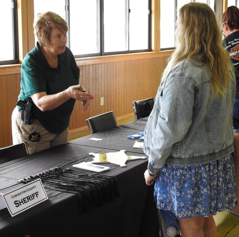 Det. Nancy Wilt talks to attendee of an employment expo by Ohio Means Jobs of Coshocton County at the Lake Park Pavilion.