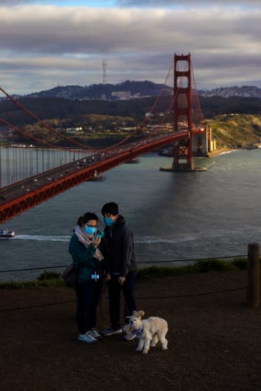 SAN FRANCISCO, CA - MARCH 13: People look at their selfie with the Golden Gate bridge in the background taken from Battery Spencer, former Fort Baker site, on Saturday, March 13, 2021 in San Francisco, CA. On March 2, 2021, the San Francisco Department of Public Health updated a COVID-19 health order to allow many businesses to reopen at the Red Tier. (Gary Coronado / Los Angeles Times)