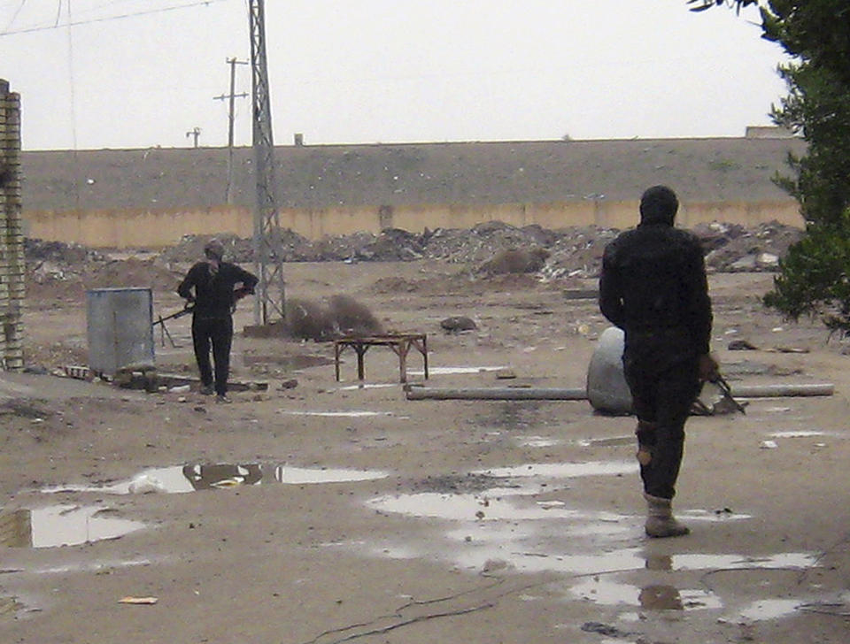 In this Saturday, Jan. 11, 2014 photo, gunmen stand guard in Fallujah, 65 kilometers (40 miles) west of Baghdad, Iraq. Fighting between security forces and al-Qaida-linked militants in Iraq's Sunni-dominated Anbar province has killed at least 60 people over the past two weeks, an official said Saturday. International observers have warned of shortages of food, fuel and other necessities, particularly in Fallujah. United Nations records show that more than 11,000 families have been uprooted by the fighting. (AP Photo)