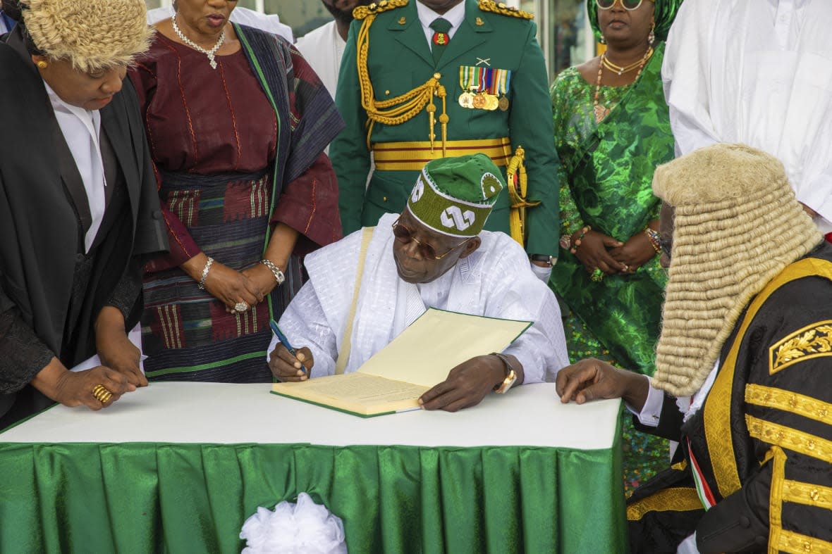In this photo released by the Nigeria State House, Nigeria’s new President Bola Ahmed Tinubu, signs a document after taking the oath of office at a ceremony in Abuja Nigeria, Monday May 29, 2023. (Sunday Aghaeze/Nigeria State House via AP)