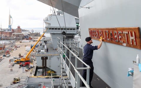 Able Seaman Ryan Whatmore, polishes the name board of HMS Queen Elizabeth. - Credit:  Andrew Matthews/PA