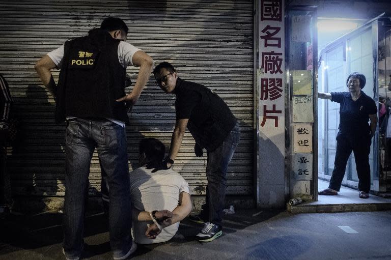 Police arrest a protester as they try to clear a road at a pro-democracy protest site in the Mongkok district of Hong Kong on November 25, 2014