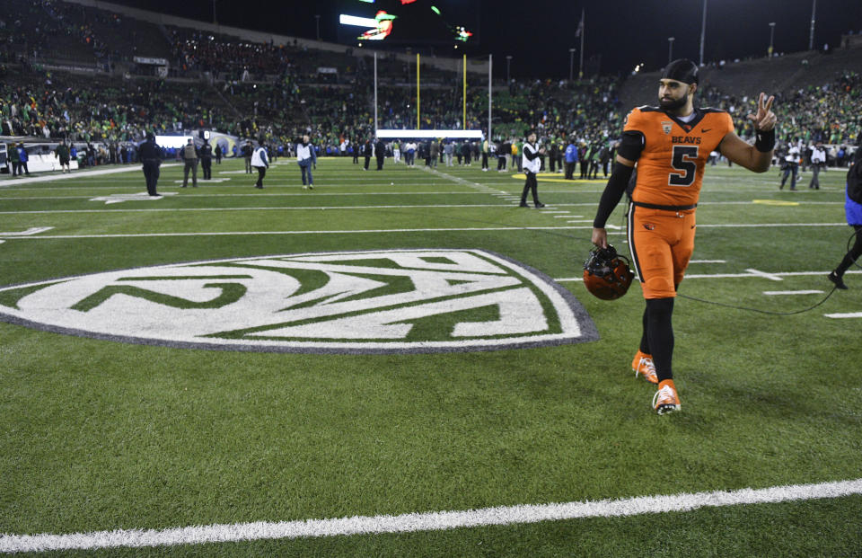 Oregon State quarterback DJ Uiagalelei (5) walks by the Pac-12 logo and waves to fans after the team's NCAA college football game against Oregon, Friday, Nov. 24, 2023, in Eugene, Ore. This was the final Pac-12 football game for the team. (AP Photo/Mark Ylen)