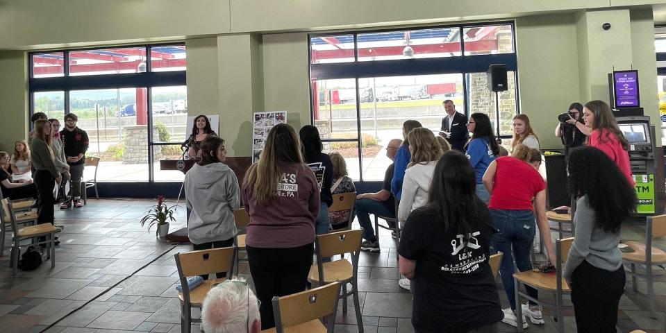 Students stand as their names are called to be recognized for their work on the mural.