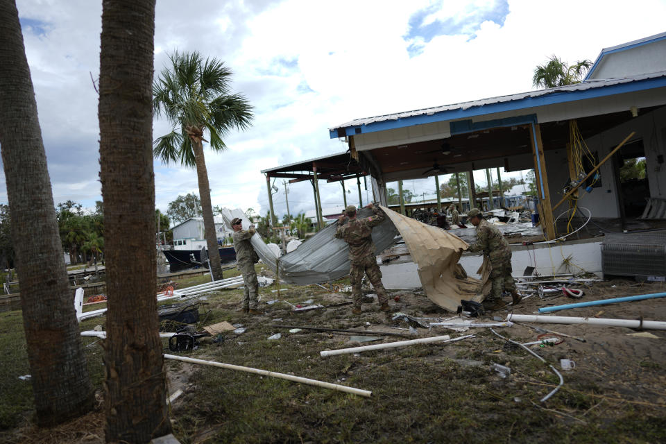 Members of the National Guard assist storm-damaged business The Marina with moving and piling debris, in Horseshoe Beach, Fla., Thursday, Aug. 31, 2023, one day after the passage of Hurricane Idalia. (AP Photo/Rebecca Blackwell)