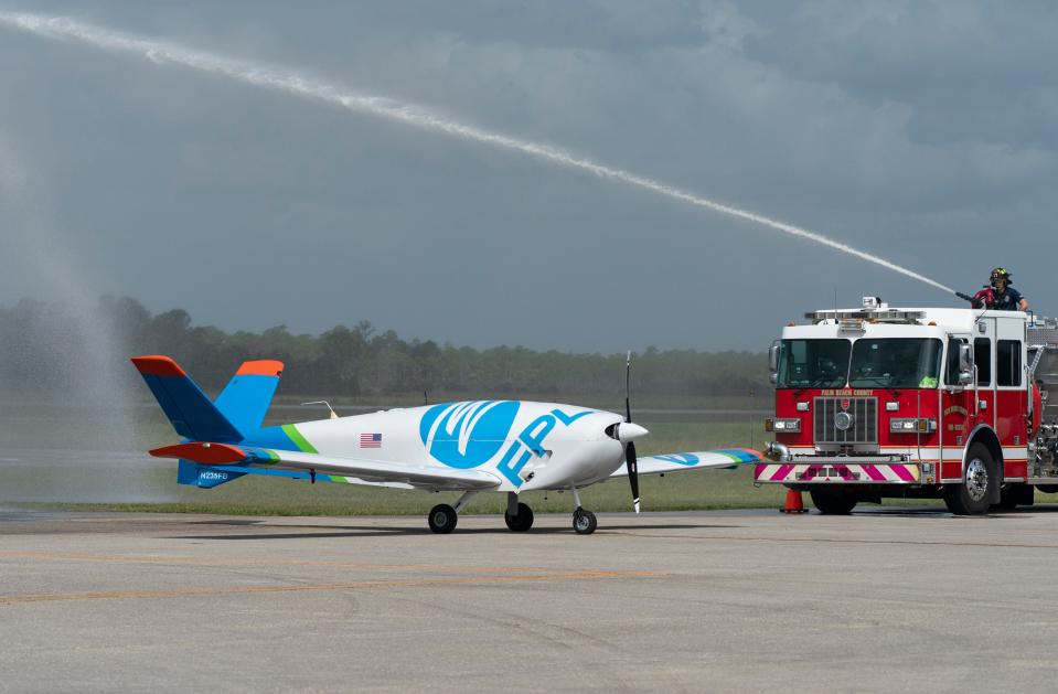 A Palm Beach County Fire Rescue firefighter at the North Palm Beach County General Aviation Airport sprays water on FPL's new FPLAir One, a remotely operated fixed-wing drone that is designed to help maintain the energy grid and speed power-restoration times after severe weather.