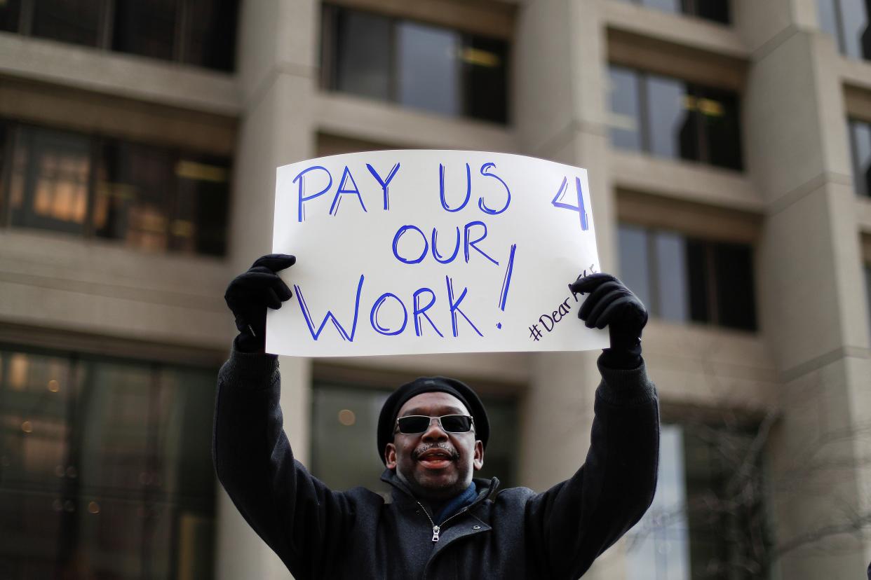 Christopher Belcher, a Department of Veterans Affairs employee, holds a sign during a rally to call for an end to the partial government shutdown, in Detroit, Thursday, Jan. 10, 2019. (AP Photo/Paul Sancya) ORG XMIT: MIPS105