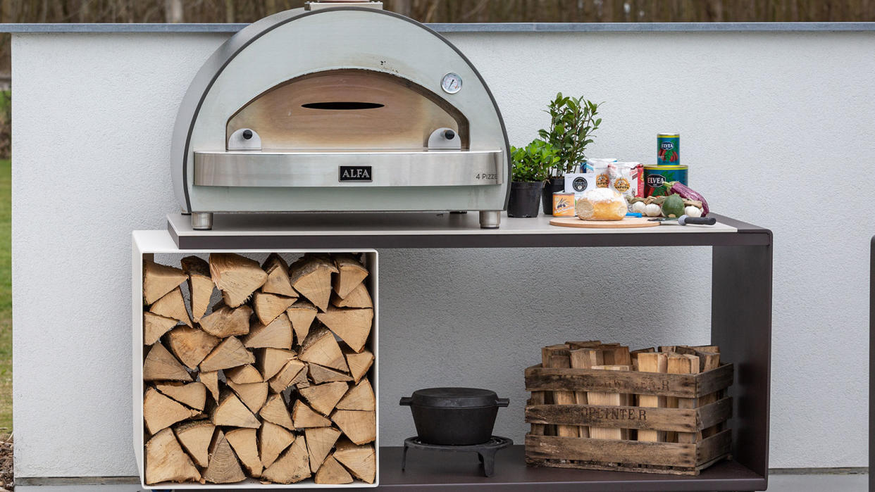  wood fired pizza oven with logs stored underneath 