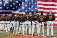 The Baltimore Orioles stand for the national anthem before an opening day baseball game against the Boston Red Sox, Friday, April 2, 2021, in Boston. (AP Photo/Michael Dwyer)