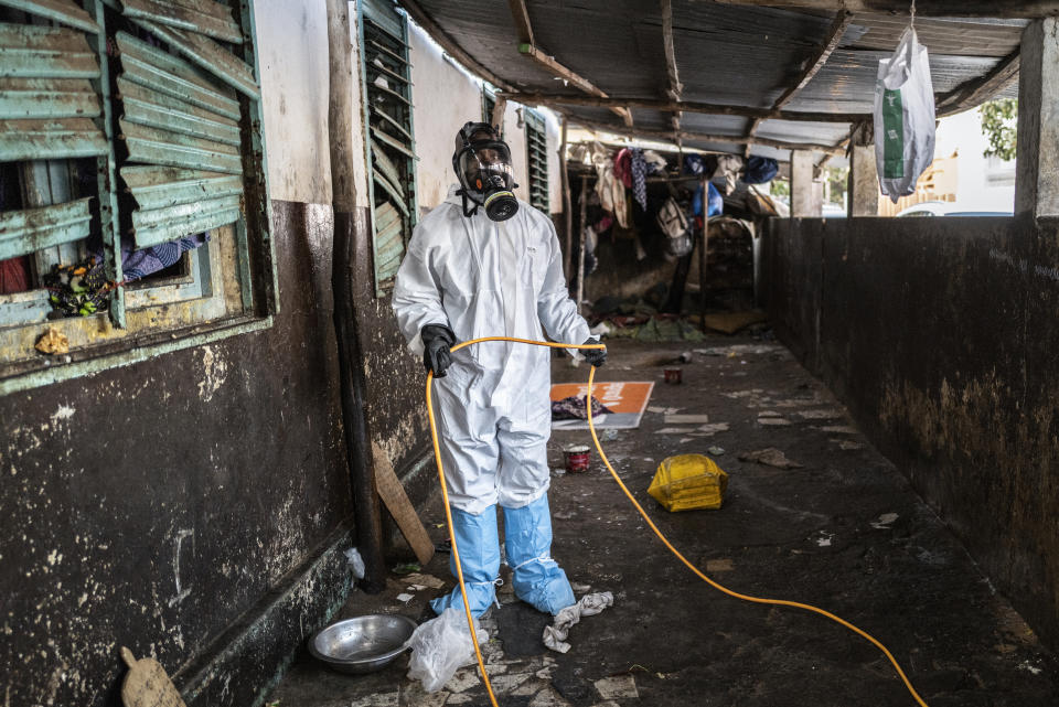 In this Wednesday, April 1, 2020, photo, a municipal worker sprays disinfectant in a Quran school to help curb the spread of the new coronavirus in Dakar, Senegal. The new coronavirus causes mild or moderate symptoms for most people, but for some, especially older adults and people with existing health problems, it can cause more severe illness or death. (AP Photo/Sylvain Cherkaoui)