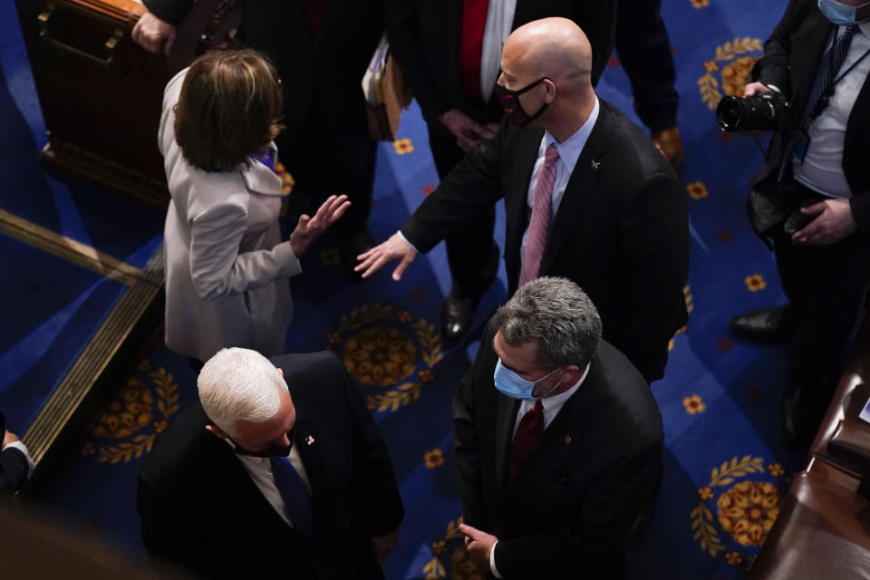 Vice President Mike Pence, bottom left, talks as House Speaker Nancy Pelosi, D-Calif., talks with Pence's chief of staff Marc Short after the final certification of Electoral College votes cast in November's presidential election during a joint session of Congress after working through the night, at the Capitol in Washington, Thursday, Jan. 7, 2021. Violent protesters loyal to President Donald Trump stormed the Capitol Wednesday, disrupting the process. (AP Photo/Andrew Harnik)