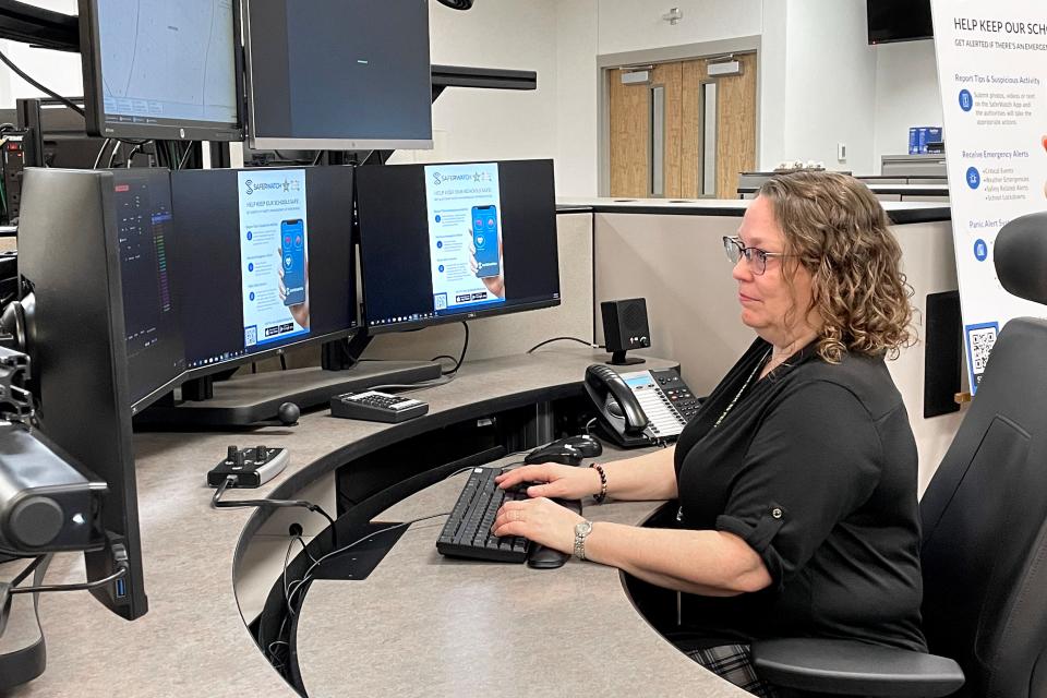 Communications Officer Denise Sledge demonstrates the SaferWatch system at the Okaloosa County Sheriff's Office's 911 Communications Center. SaferWatch uses a phone-based app that allows school teachers, administrators and staff to access a quick alert system linked directly to the Communications Center.