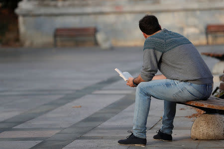 Alireza, an Iranian refugee living in Turkey, reads a book at a park in central Istanbul, Turkey, November 15, 2017. Picture taken November 15, 2017. REUTERS/Murad Sezer