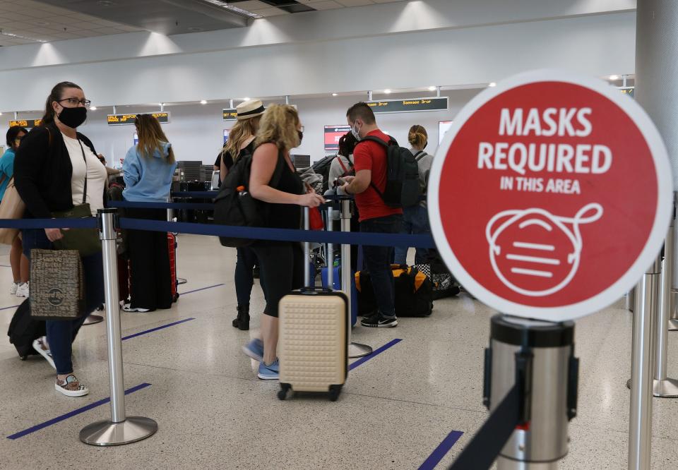Travelers prepare to check in for their Delta Air Lines flight at the Miami International Airport on Feb. 1 in Florida. An executive order signed by President Joe Biden mandates mask-wearing on federal property and on public transportation as part of his plan to combat the coronavirus pandemic.