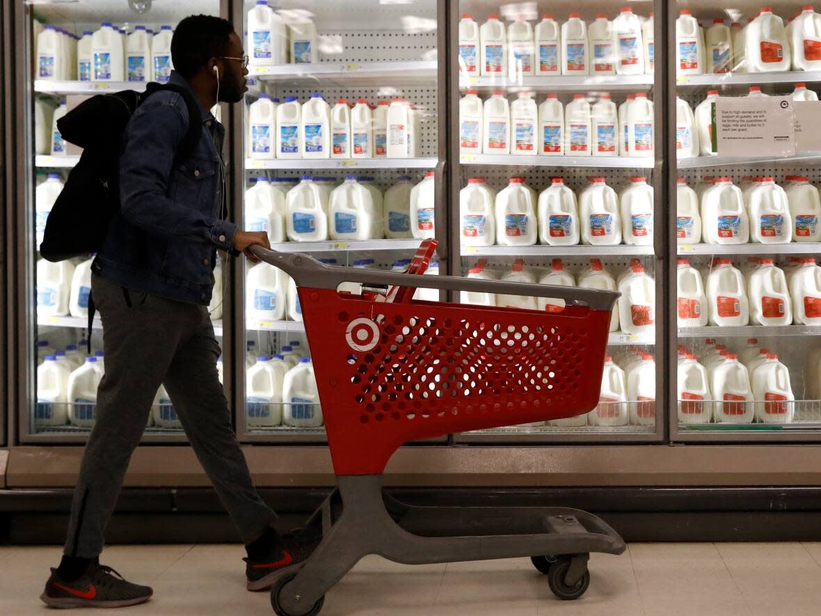 A shopper walks past the milk and dairy display case at a Target store in Manhattan. Canadian Food Inspection Agency laboratories have tested 142 retail milk samples from across Canada to spot any traces of bird flu, amid an outbreak of H5N1 in the U.S., officials say. (Brendan Mcdermid/Reuters - image credit)