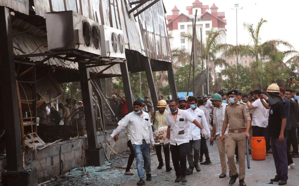 Rescuers carry the body of a person killed in the fire