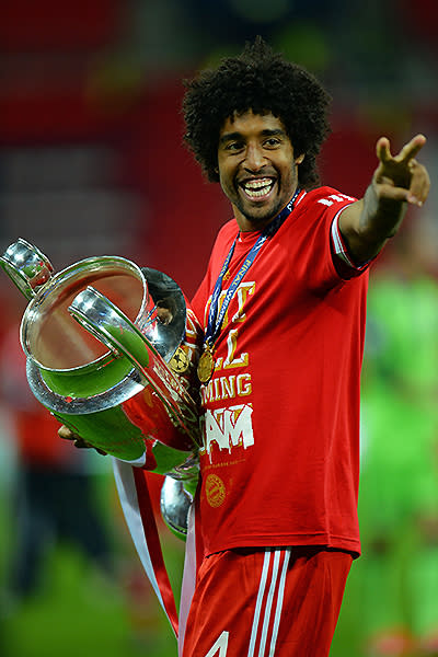 Dante of Bayern Muenchen holds the trophy.