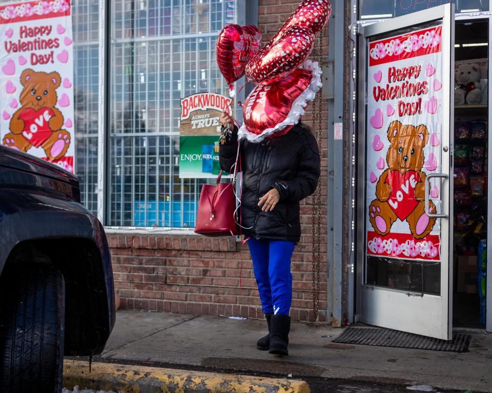 A woman exits a Dollar General on Valentine's Day in 2021 with balloons in hand for her great nieces and great nephews.