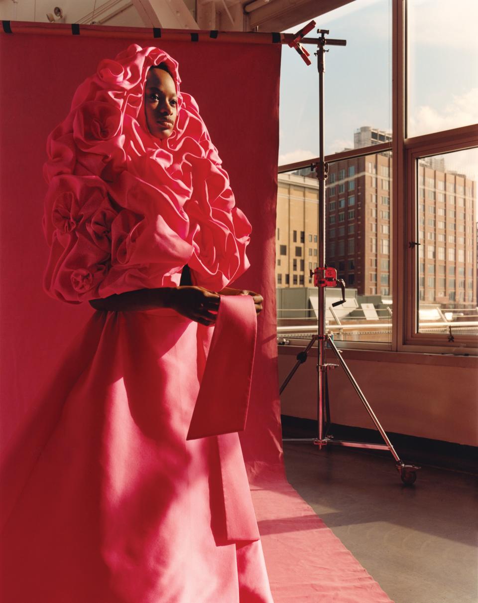 Model Mayowa Nicholas in the rose-scattered cape and skirt that opened Valentino’s spring 2019 haute couture collection. Fashion Editor: Camilla Nickerson. Hair: James Pecis; Makeup: Dick Page; Manicure: Megumi Yamamoto. Produced by Alexis Piqueras for Rosco Production.