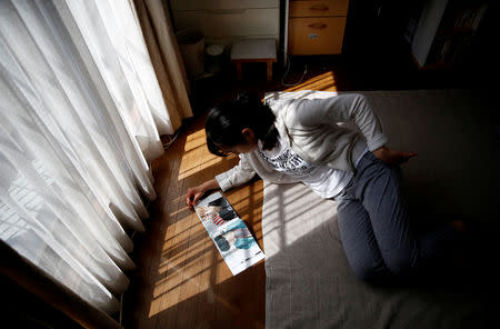Nao Niitsu, 19, college freshman from Tokyo, who wants to be a K-pop star, looks at BTS's photo book in her room in Tokyo, Japan, March 20, 2019. REUTERS/Kim Kyung-Hoon