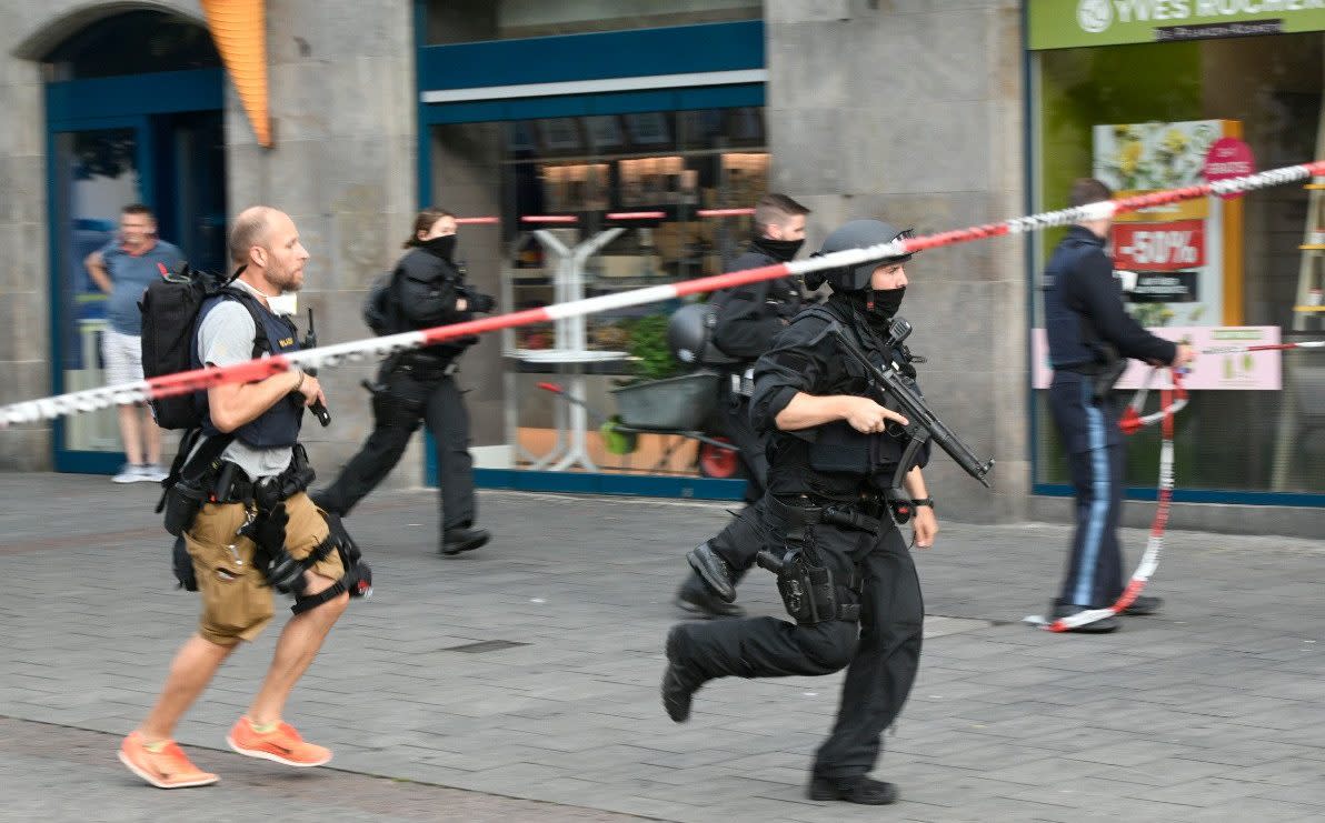 Armed officers run across the street - REUTERS/Thomas Obermeier