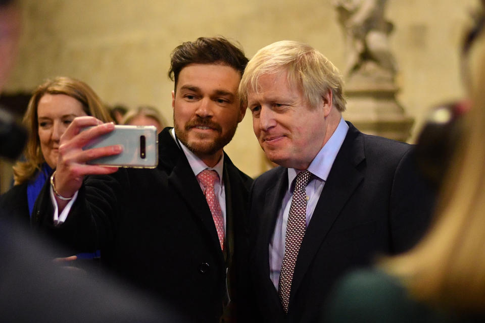 Prime Minister Boris Johnson poses for photographs as he welcomes the newly elected Conservative MPs at the Houses of Parliament in Westminster, London, after the party gained an 80-seat majority in the General Election.