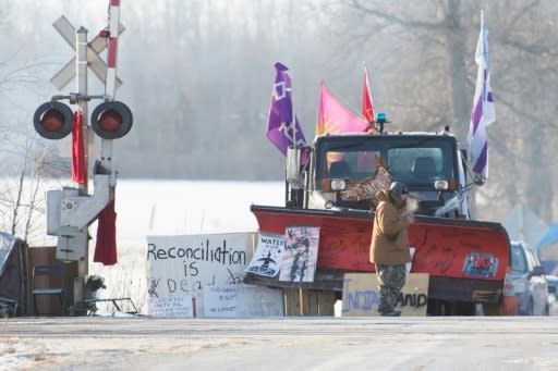 A First Nations protester walk in front of a snow plow blade that has signatures from the Wet?suwet?en hereditary chiefs as part of a train blockade in Tyendinaga, near Belleville, Ontario, Canada on February 21, 2020