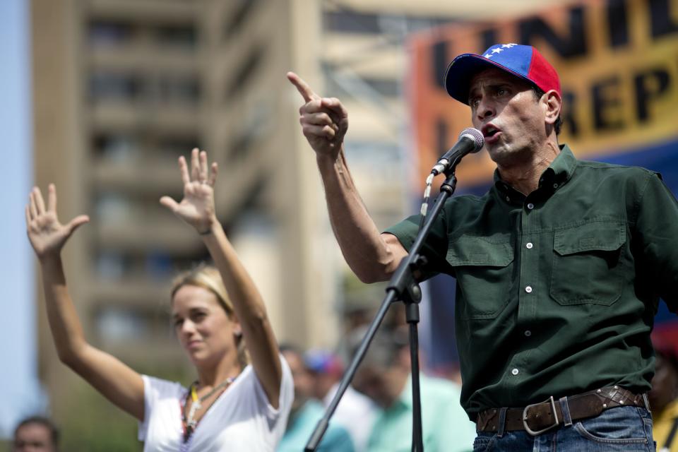 FILE - In this Feb 22, file photo, opposition leader Enrique Capriles delivers a speech next to Lilian Tintori, wife of detained opposition leader Leopoldo Lopez, during a rally in Caracas, Venezuel. Capriles says the opposition has put its differences over strategy behind them, adding that the government may have miscalculated its response to the protests as well. (AP Photo/Rodrigo Abd, File)