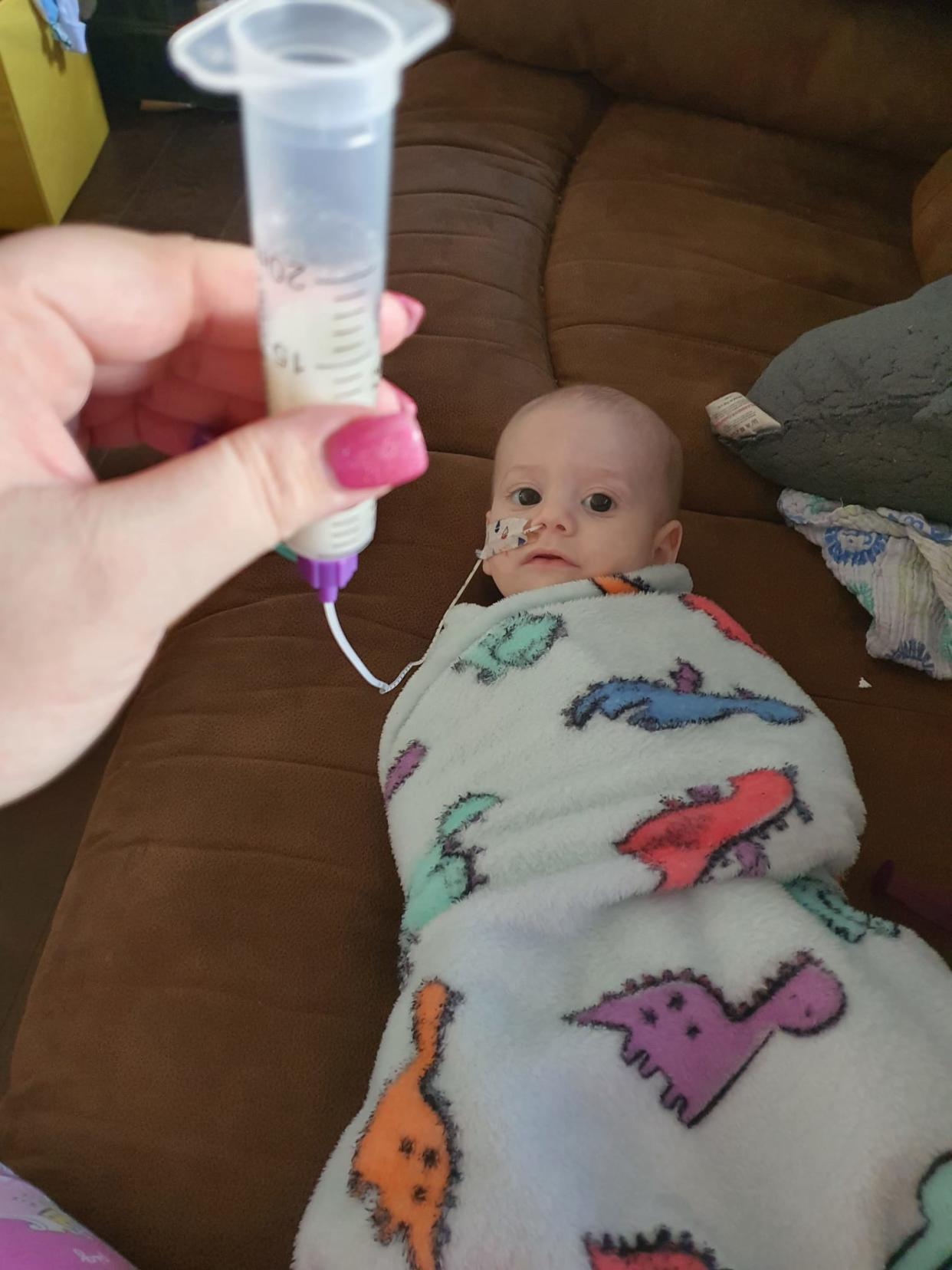 Thomas being fed by his mum through a feeding tube. (CHECT/SWNS)