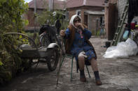 FILE - Mariia Ruban, 92, sits on a chair as she talks about the moments of the explosion next to her house that damaged its roof and windows after a Russian attack in Sloviansk, Ukraine, on Sept. 6, 2022. It's at night that residents of the eastern Ukrainian city of Sloviansk are most afraid, when rocket and artillery attacks happen more frequently. Shells and rockets slam into gardens and apartment buildings, sending chunks of masonry and shards of glass hurtling through the darkness. (AP Photo/Leo Correa, File)
